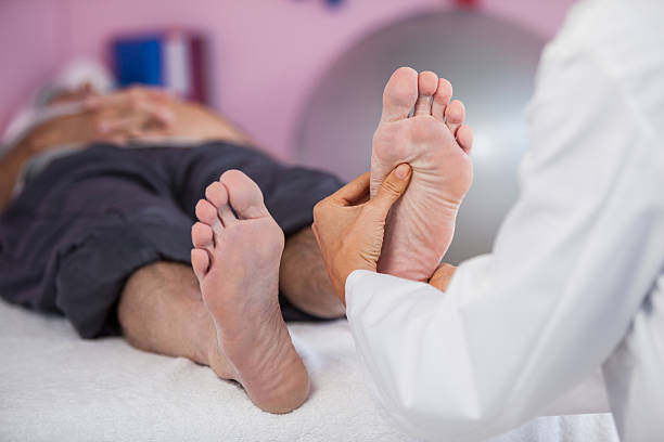 Senior man receiving foot massage from physiotherapist in clinic